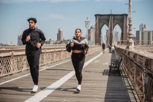 Two runners crossing the Brooklyn Bridge