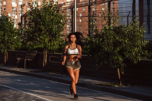 Woman jogging on a sunlit city path