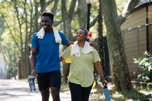 Two people smiling while walking together after a workout
